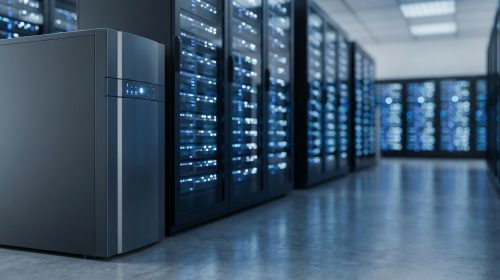Modern bir veri merkezinin koridorunda, sunucu raflarının yanında duran büyük, endüstriyel bir Kesintisiz Güç Kaynağı (UPS) ünitesi. Arka plandaki sunucuların ışıkları bulanık bir şekilde parlıyor.