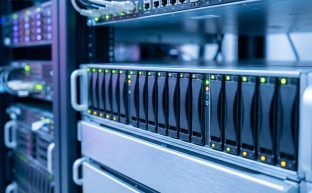 Modern bir veri merkezinde, RAID yapılandırmasını temsil eden, yanıp sönen aktivite ışıklarına sahip, sıralı sunucu sabit disklerinin (HDD/SSD) yakın çekim, fotogerçekçi bir görüntüsü.