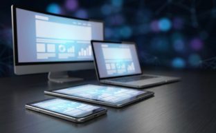 Farklı ekran boyutlarına sahip modern cihazlar (masaüstü, laptop, tablet ve akıllı telefon) üzerinde aynı web sitesi düzeninin uyumlu bir şekilde görüntülendiği, duyarlı tasarım konseptini anlatan fotogerçekçi bir görsel.